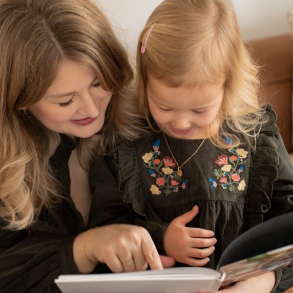 Mom reading book to daughter.